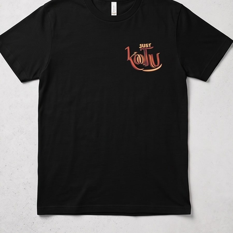 Black Just Koothu t-shirt laid flat, showing the chest logo on a light textured background.